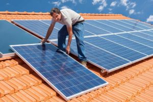 man on house rooftop installing solar panels millersburg pa